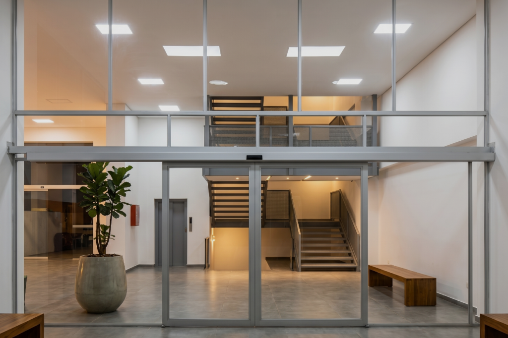 Puerta automática corredera en vidrio templado con estructura de aluminio en acceso institucional – Industrias Mendoza Rincón